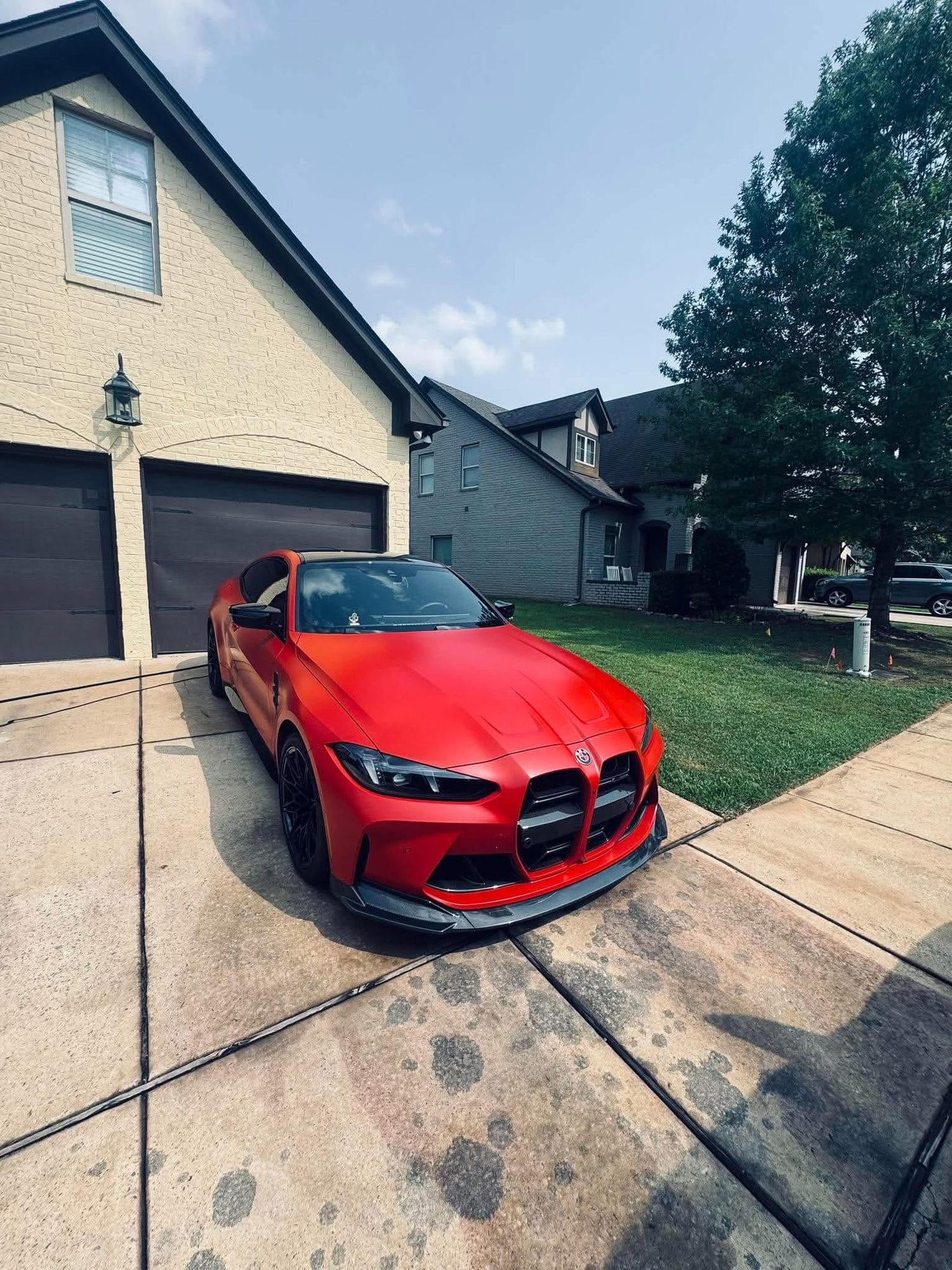 Red BMW M4 parked in a driveway after a detail